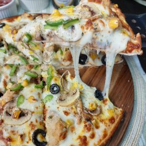 خمیر پیتزا با سس مخصوص + پنیر پیتزا + مرغ مرینت شده با سس مخصوص + قارچ + فلفل دلمه+ زیتون+ذرت شیرین